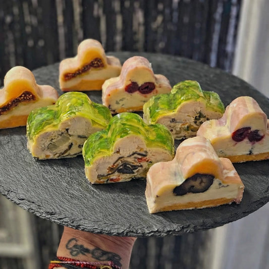 Sliced clover-shaped pâté and aspic appetizers served on a dark slate platter, created using a professional stainless steel Clover Shape terrine mold