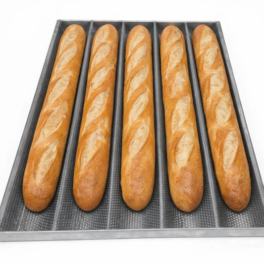 Five golden-brown crusty baguettes baked on a professional perforated stainless steel tray, demonstrating perfect heat distribution and crust results