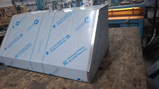Heavy-duty commercial stainless steel hood showing robust welded corner seams and exhaust collar.