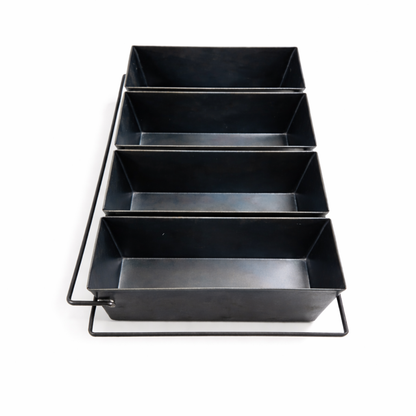 Front view of a heavy-duty 4-strap black steel loaf pan, showing deep molds designed for commercial bread baking.