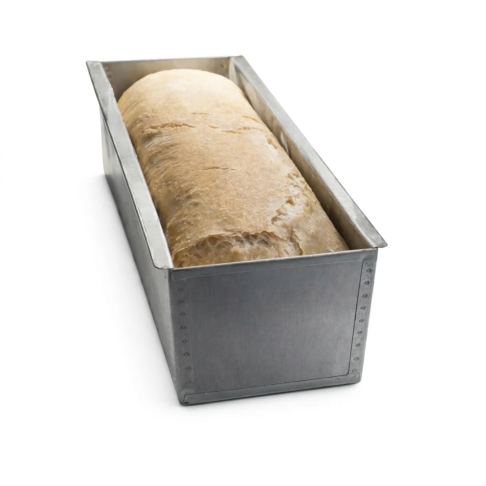 Freshly baked loaf of bread inside a professional carbon steel Pullman pan without lid.