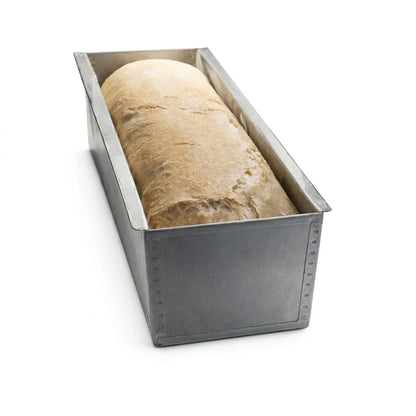 Freshly baked loaf of bread inside a professional carbon steel Pullman pan without lid.