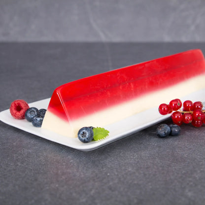 Triangular layered red and white jelly dessert with fresh berries, shaped using a professional stainless steel V-Shape terrine mold